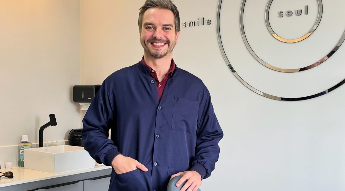 Dr. Murilo de Almeida Manoel dentista em Botucatu sorrindo no consultório moderno e humanizado